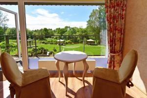 a room with a table and two chairs and a window at Pušų takas in Andrioniškis