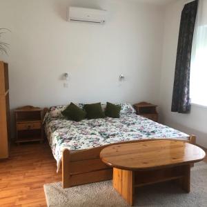 ニーレジハーザにあるPiroska Vendégházのベッドルーム1室(ベッド1台、木製テーブル付)