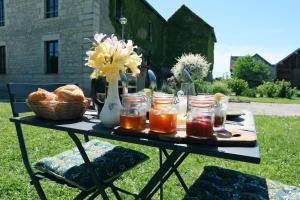 a table with jars of honey and a basket of bread at Arc en Sel Maison d’hôtes in Arc-et-Senans