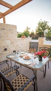 - une table avec des assiettes de nourriture sur une terrasse dans l'établissement Kastro Apartments, à Panormos Rethymno
