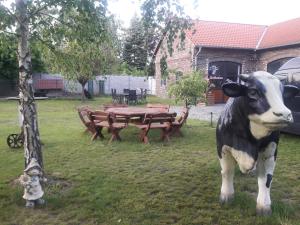 a statue of a cow standing in a yard at Pension NELE für Monteure NAHE Berlin in Mittenwalde +8 photos
