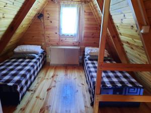 a room with two beds in a log cabin at BURSZTYN 3 in Rusinowo