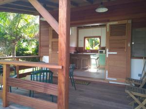 a porch of a house with a table and chairs at Un cosy sous le vent in Gourbeyre