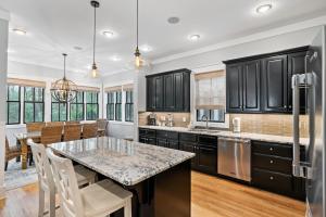 a kitchen with black cabinets and a large island at 13 Lake District Lane in Santa Rosa Beach
