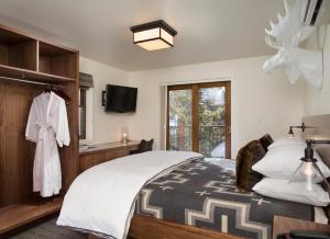 a bedroom with a bed and a tv and a window at Hotel Durant in Aspen
