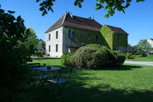 une table et des chaises devant un bâtiment dans l'établissement Arc en Sel Maison d’hôtes, à Arc-et-Senans