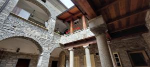 a stone building with a column and a balcony at B&B la Forgia in Bettola