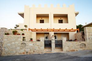 una casa con una puerta y una pared de piedra en Kastro Apartments, en Panormos Rethymno