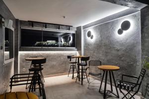 un bar con sgabelli e tavoli in una stanza di A.P. Acropolis View Apartments ad Atene