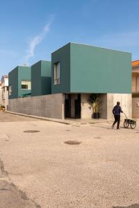 un homme tirant une charrette devant un bâtiment dans l'établissement Casa d´Avó Dalina, à Figueira da Foz