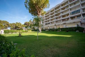 an apartment building with a green lawn in front of it at 2BD-Piscina-Playa-Port Aventura2 in Salou