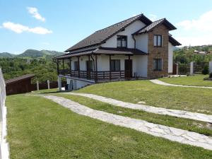 una casa en una colina con un patio de hierba en Vila Aloman, en Sebeş
