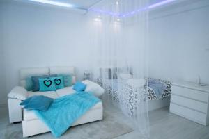 a white bedroom with a bed with blue pillows at Apartamento Séptimo cielo primera línea de mar in Blanes
