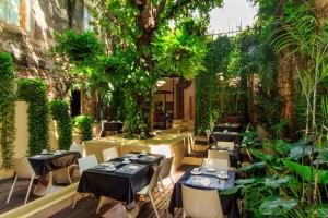 a restaurant with tables and chairs and a tree at Hotel Casa Lola Deluxe Gallery in Cartagena de Indias