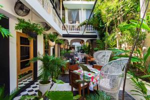 an outdoor patio with chairs and plants at Hotel Casa Lola Deluxe Gallery in Cartagena de Indias