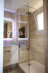 a glass shower in a bathroom with a sink at ANTONIA2 in Brides-les-Bains