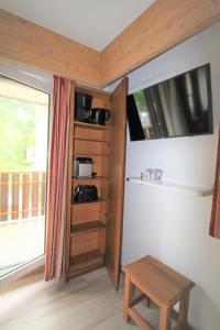 una camera con mensola in legno, tavolo e finestra di ANTONIA2 a Brides-les-Bains