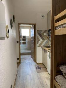 a kitchen with wooden floors and a door leading to a bathroom at ANTONIA2 in Brides-les-Bains