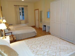 a bedroom with two beds and a table and a mirror at Redwood Apartment in Killarney