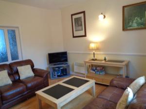 a living room with two leather couches and a coffee table at Redwood Apartment in Killarney