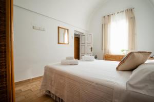 a bedroom with a large bed with white sheets at Il pergolato sul mare in Monopoli