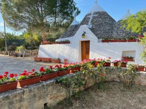 a house with flowers in front of it at Trullo Bianco in Putignano
