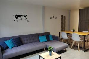 a living room with a couch and a table at Le Blue, appartement de standing en hyper-centre in Sarreguemines +12 photos