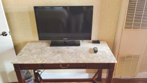 a television on top of a table with a remote control at Pacific Heights Inn in San Francisco