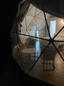 COSMOS GLAMPING ARTEAGA في أرتياغا: غرفة بها كراسي وطاولة في خيمة