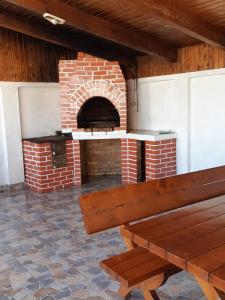 un horno de ladrillo con un banco de madera delante de él en Vila Aloman, en Sebeş