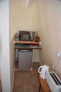 a small kitchen with a table with a microwave at The Garrett in Melcombe Regis