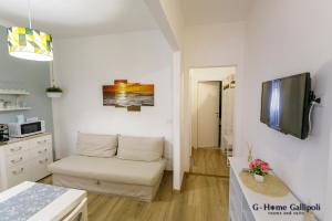 G-Home Gallipoli rooms and suite في غالّيبولي: غرفة معيشة مع أريكة وتلفزيون بشاشة مسطحة