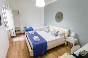 G-Home Gallipoli rooms and suite في غالّيبولي: غرفة صغيرة بسريرين وطاولة