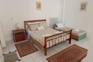 a bedroom with a bed and two rugs at Semith Home 1 in Kalabaka