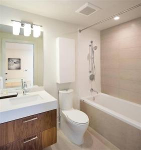 a bathroom with a toilet and a sink and a tub at Luxury Highrise Living Downtown LA in Los Angeles