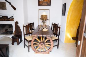 uma sala de jantar com uma mesa de madeira e uma roda em Mili Art Home em Naxos Chora