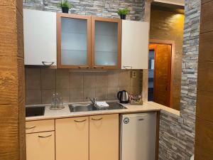 uma cozinha com armários castanhos e um lavatório em Deluxe 217 em Borovets