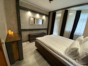 1 dormitorio con cama, mesa y ventana en Deluxe 217 en Borovets