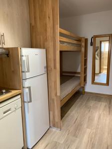 a kitchen with a refrigerator and bunk beds at ANTONIA2 in Brides-les-Bains