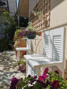 a white chair sitting on a patio with flowers at ILIOS apartment in Nydri
