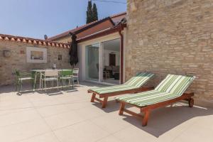 a patio with two lawn chairs and a table and chairs at Kuća za odmor Mihaela in Sutivan