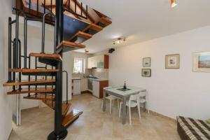 a living room with a spiral staircase and a table at Kuća za odmor Mihaela in Sutivan