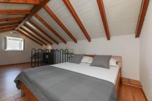 a bedroom with a large bed in a room with wooden floors at Kuća za odmor Mihaela in Sutivan