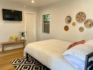 1 dormitorio con 1 cama y TV en la pared en Steps To The Beach, Pacific City and Main Street - Studio, en Huntington Beach