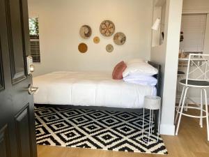 a small bedroom with a bed and a black and white rug at Steps To The Beach, Pacific City and Main Street - Studio in Huntington Beach +16 photos