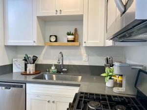 a kitchen with white cabinets and a sink at Steps To The Beach, Pacific City and Main Street - Studio in Huntington Beach