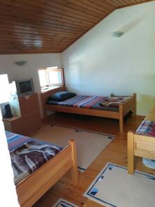 a room with two beds and a wooden ceiling at Holiday home Raduš in Virpazar