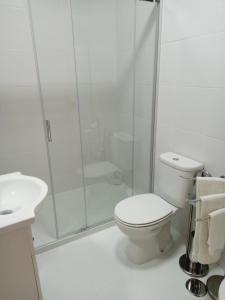 a white bathroom with a toilet and a shower at Bela Vista in Viana do Castelo