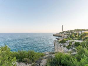 a lighthouse on a cliff next to the ocean at Torredembarra House in Torredembarra