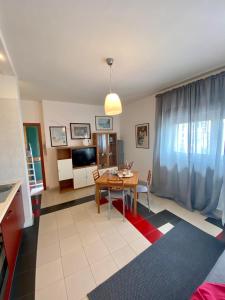 uma sala de estar com uma mesa e uma televisão em Villa Centaurea Apartment with private parking em Taormina